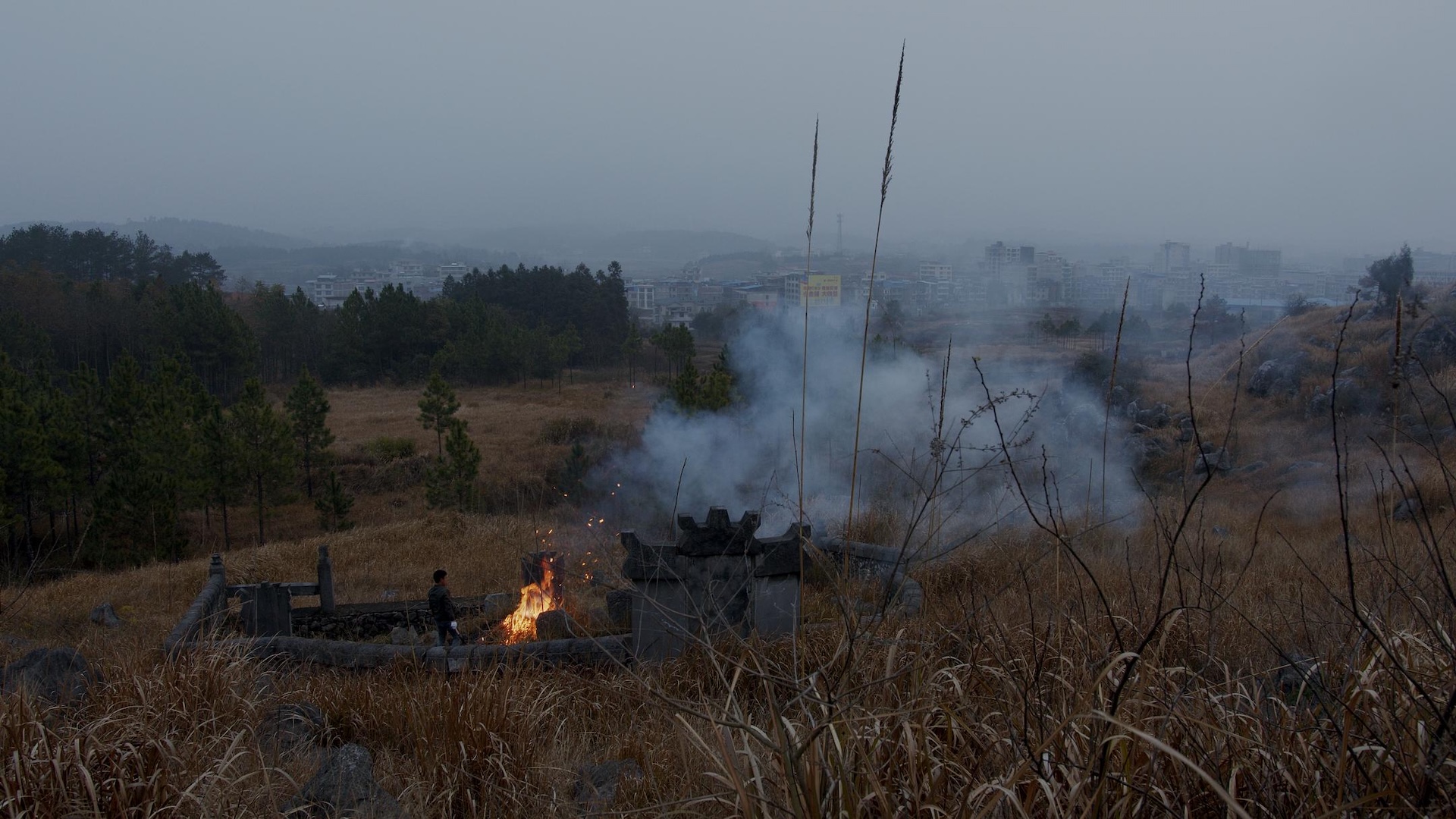 A man beside a fire among hillside graves, from Some Manifestations of the South